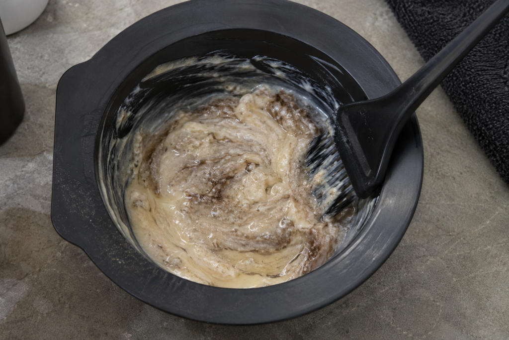 Close-up of hair color cream with a separated, grainy texture in a mixing bowl